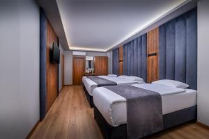 a row of four beds in a hotel room at Hotel And free shuttle in Istanbul