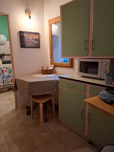 a small kitchen with a table and a microwave at Gîte dans La circulade - Le Pouget in Le Pouget