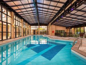 a large swimming pool with a large building at Pinheiros Luxuoso Flat em hotel 4 star in São Paulo