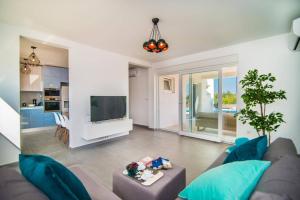 een woonkamer met een bank en een tv bij Villa Florentina by Villa Plus in Štokovci