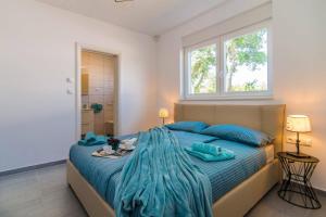 een slaapkamer met een bed met blauwe kussens en een raam bij Villa Florentina by Villa Plus in Štokovci +16 foto's