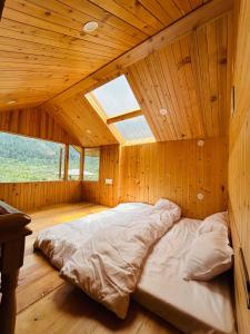 a large bed in a room with a wooden ceiling at Himalayan Baseraa in Sainj