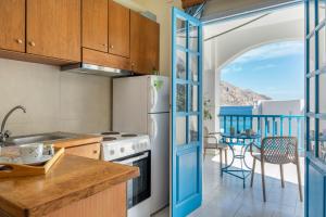 Una cocina con una puerta azul que da a un balcón. en Hotel Glaros Karpathos, en Diafani