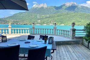 a table on a deck with a view of the water at Le Panoramique Rivage - Terrasse privative in Duingt