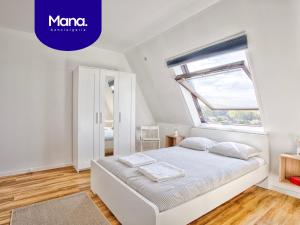 a white bedroom with a bed and a window at Appartement classé 2 étoiles à Cabourg - Proche plage et centre-ville in Cabourg