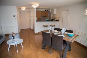 a kitchen and dining room with a wooden table and chairs at Le Panoramique Rivage - Terrasse privative in Duingt +5 photos
