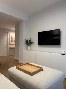un soggiorno con TV su una parete bianca di Apartamento Bailatús a Saragozza