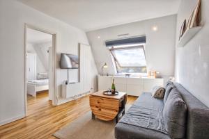 a living room with a couch and a table at Appartement classé 2 étoiles à Cabourg - Proche plage et centre-ville in Cabourg