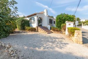 a small white house with a driveway at Villa Margarita in Casas de Torrat