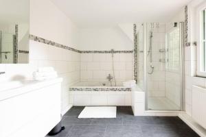 a white bathroom with a tub and a shower at Carpe Deimern in der Lüneburger Heide in Soltau