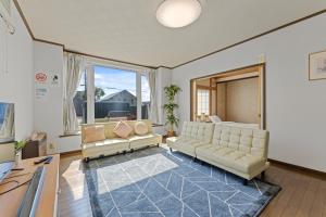 - un salon avec des canapés et une grande fenêtre dans l'établissement Yotei View House, à Kutchan