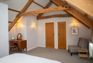 Un dormitorio con una cama, un escritorio y una silla. en The Dovecote Llechryd, en Llechryd