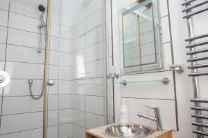 Un baño con ducha con lavabo y espejo. en The Dovecote Llechryd, en Llechryd 23 fotos más