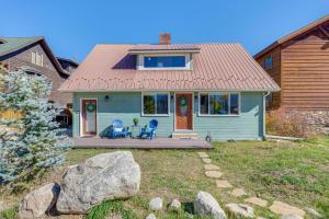 a blue house with two chairs and a porch at Walk to Water Grand Lake Home with Hot Tub! in Grand Lake