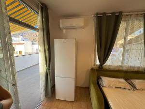 a room with a refrigerator and a bed and a window at Beautiful Apartment Spectacular Terrace in Puerto de Santiago