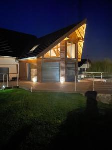a wooden house with a garage at night at Chez Nouchka 