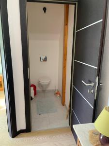 a bathroom with a door leading to a toilet at Chez Nouchka 