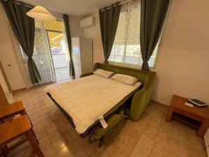 a bedroom with a bed with a green couch at Beautiful Apartment Spectacular Terrace in Puerto de Santiago
