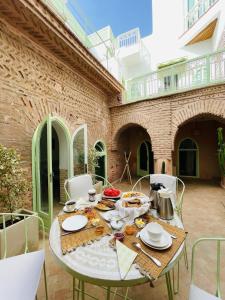 a table with food on it in a courtyard at Riad Birdy, Charmant et privatif, Piscine, Rooftop, 6 suites, 2 salons, Wifi in Marrakesh