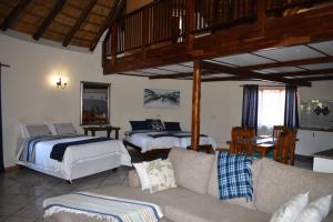 a living room with two beds and a couch at Impangele Lodge in Muldersdrift