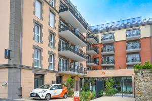 a car parked in front of a building at Les Belles Lettres in Herblay