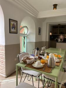 a green table with food on it in a kitchen at Riad Birdy, Charmant et privatif, Piscine, Rooftop, 6 suites, 2 salons, Wifi in Marrakesh