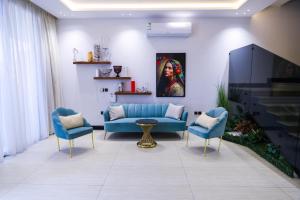 a living room with a blue couch and two chairs at The Land Resort in Riyadh
