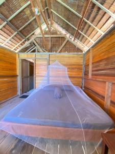 a large bed in a room with a roof at Marlina Homestay in Fam