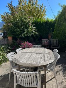 a wooden table with four chairs around it at Maison de charme " Les Cyclamens" in Saint-Jorioz