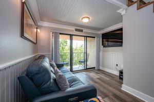 un salon avec un canapé en cuir bleu et des portes coulissantes en verre dans l'établissement 712H Studio Loft One Bath, à Thayerville