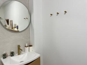 a bathroom with a sink and a mirror at Appartement de Charme au cœur de Montendre in Montendre