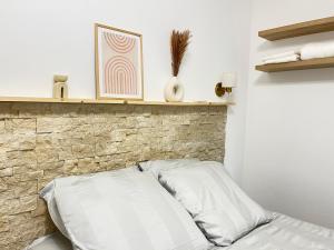 a bed in a room with a brick wall at Appartement de Charme au cœur de Montendre in Montendre