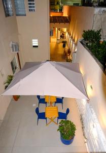 an umbrella over a table and chairs on a balcony at Barra Comfort Pousada in Salvador