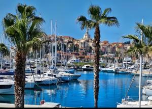 a marina with palm trees and boats in the water at Casa vacanza Teresita 300mt Mare in Imperia