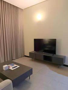 a living room with a flat screen tv and a coffee table at فندق ايون - حي الملك عبد العزيز in Riyadh