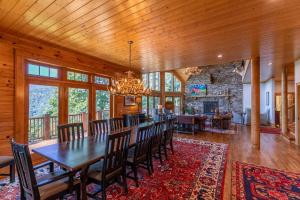 una sala da pranzo con tavolo, sedie e camino di A High Country Retreat a Boone