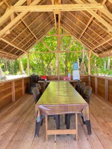 a wooden table in a pavilion with a green table and chairs at Marlina Homestay in Fam