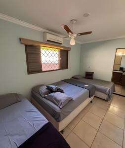 a bedroom with two beds and a window at Chácara c/piscina, área para eventos e 4 quartos in Ribeirão Preto +44 photos