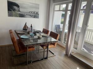ein Esszimmer mit Tisch und Stühlen und Fenstern in der Unterkunft Traumferienwohnung Ostseebad Baabe - Rügen in Baabe + 8 Fotos