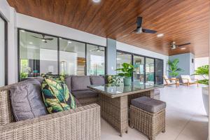 un salon avec un canapé et une table en verre dans l'établissement Uvita-new Luxury-sleeps 6-private Pool-huge Patio, à Uvita