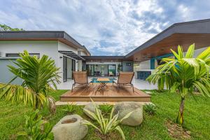 une maison avec deux chaises et une table dans la cour dans l'établissement Uvita-new Luxury-sleeps 6-private Pool-huge Patio, à Uvita