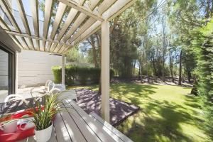 Un banco blanco debajo de una pérgola en un patio. en Ocean Village Eden, en Tróia