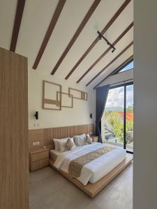 a bedroom with a large bed and a large window at LM Home 2 Mendira in Candidasa