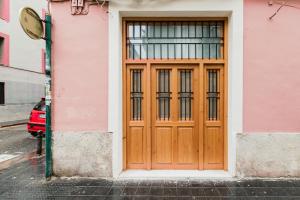 バレンシアにあるNew Studio - La puerta de olivoのピンクの建物側の木製ドア