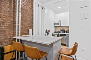 a kitchen with a white counter and a brick wall at Lavish Downtown Manhattan Oasis in Union Square in New York