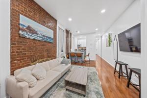 a living room with a couch and a brick wall at Lavish Downtown Manhattan Oasis in Union Square in New York