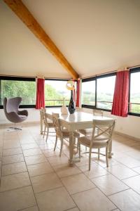 a dining room with a table and chairs and windows at La bastide de Meilhouret in Larroque