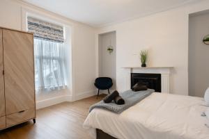 Un pat sau paturi într-o cameră la 4-Bedroom Coastal Getaway in Pembroke Dock