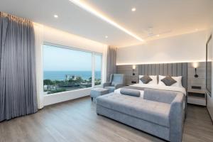 a bedroom with a bed and a couch and a large window at OCEAN PEARL in Visakhapatnam
