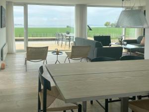 a living room with a table and chairs and a couch at Holiday Home With Panoramic Views And Nature Pool in Harpelunde